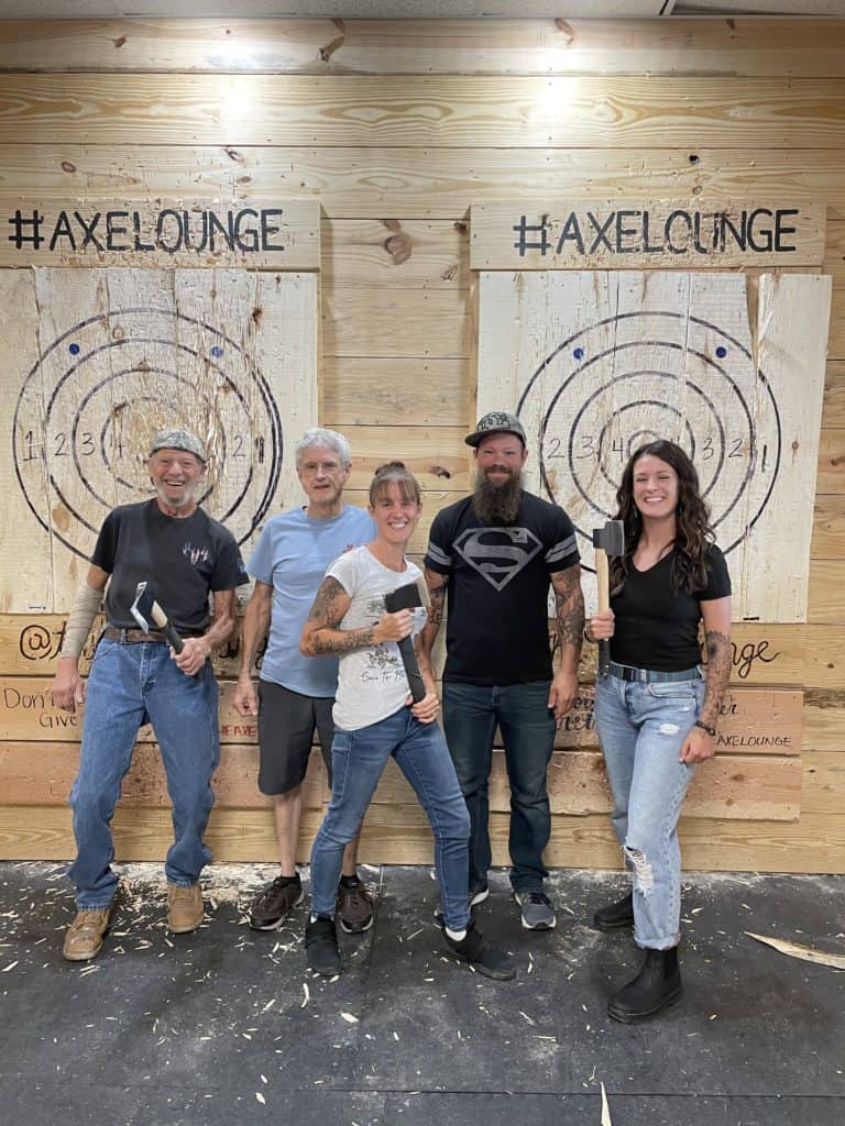 friends posing at an indoor axe throwing lane