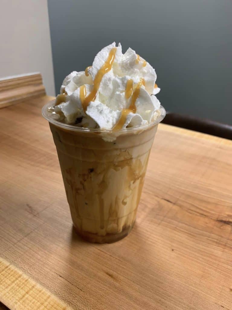 iced latte with whipped cream at the axe and grind coffee bar