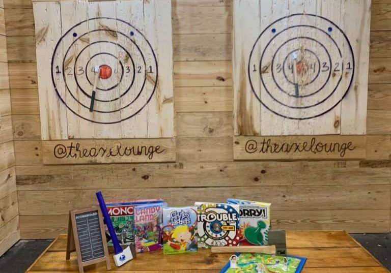 several board games and axes in front of targets at the axe lounge indoor lanes